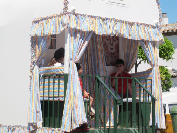 A carreta, complete with curtained, shaded outside balcony, sets off on El Rocio.