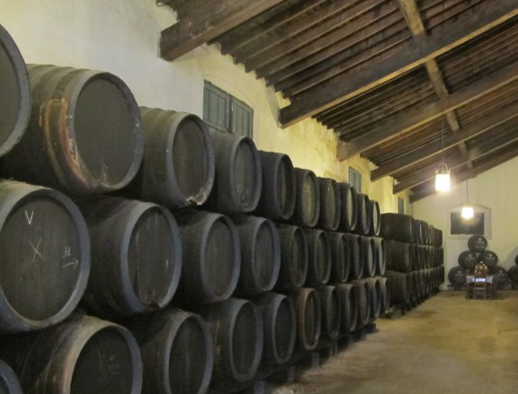 A Spanish wine bodega, stacked with barrels.