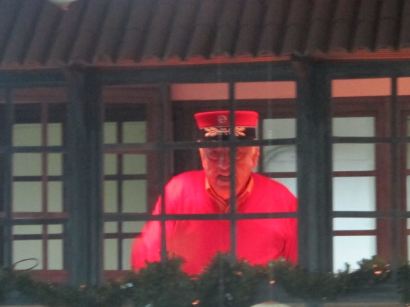 Resplendent in his scarlet uniform, the station master keeps an eye on the action from his signal box.