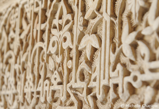 Plant motifs and decorative inscriptions of calligraphy running horizontally across walls in the Alhambra, Granada Plant motifs and decorative inscriptions of calligraphy running horizontally across walls in the Alhambra, Granada