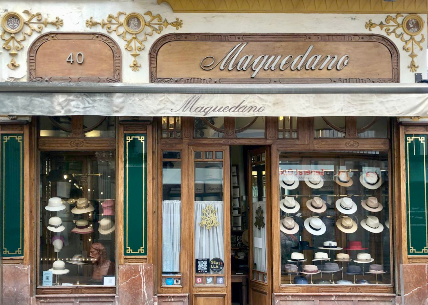 Marble and carved wood frame the historic facade of Maquedano Hat Shop in Seville © Fiona Flores