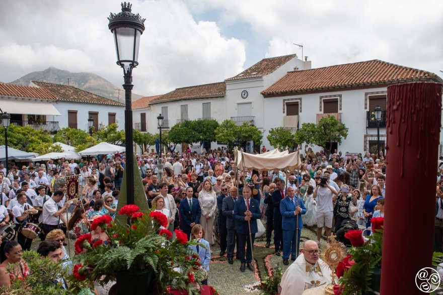  The Corpus procession passes through the Plaza de España in the village of Benalmadena. The priest gives a blessing at the ornate open-air altar and the town band accompanies the procession. © Michelle Chaplow
