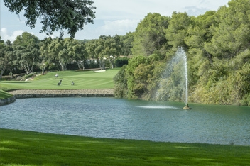 Serene view at Valderrama Golf Course, framed by ancient cork oak trees with a sparkling lake and fountain © Michelle Chaplow