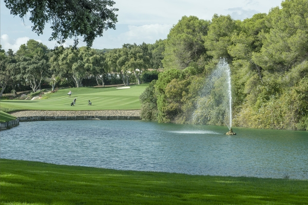 Serene view at Valderrama Golf Course, framed by ancient cork oak trees with a sparkling lake and fountain © Michelle Chaplow