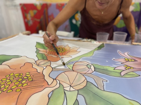 Silvia Ramos hand painting floral designs on silk. © Artist