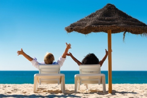 Carefree couple sunbathing by the sea © iStock